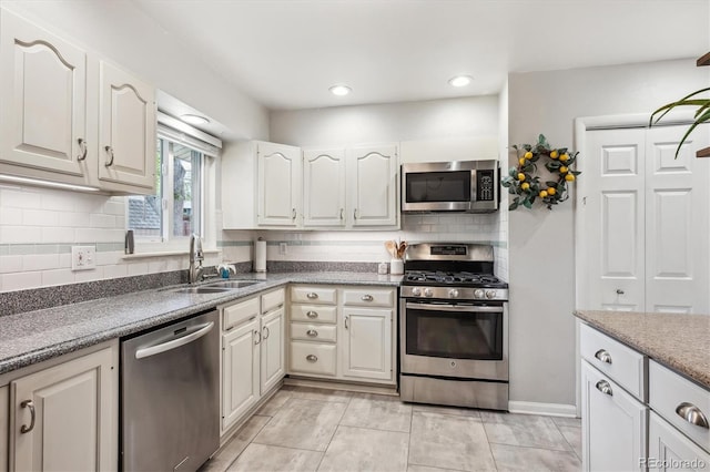 6410 Independence Way, Arvada, CO 80004 - kitchen featuring stainless steel appliances, a sink, decorative backsplash, white cabinetry, and recessed lighting