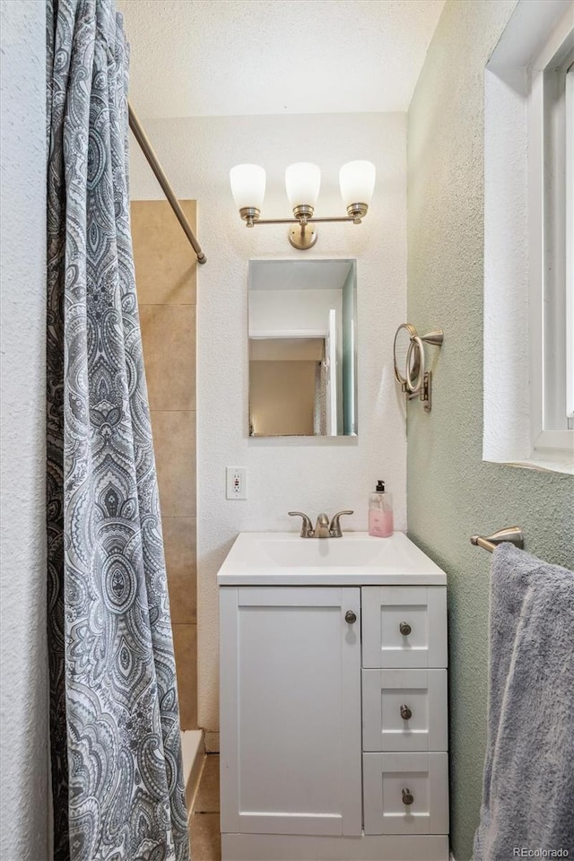 6410 Independence Way, Arvada, CO 80004 - full bath with curtained shower, a textured wall, and vanity