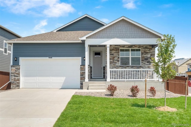 view of front of house with a garage, covered porch, and a front lawn