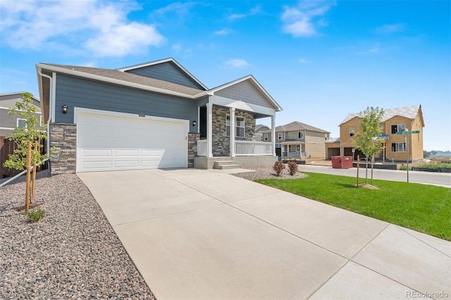 view of front of house with a garage, a front lawn, and covered porch