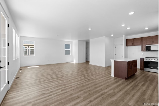 737 Muturu Rd, Johnstown, CO 80534 - kitchen featuring electric range, open floor plan, recessed lighting, light wood finished floors, and baseboards