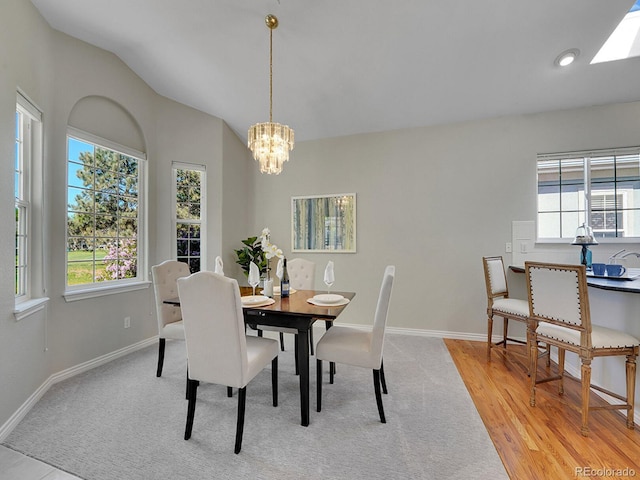 946 Champion Cir, Longmont, CO 80503 - dining room featuring healthy amount of natural light, a chandelier, baseboards, and lofted ceiling