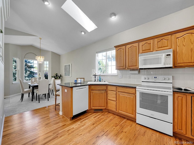 946 Champion Cir, Longmont, CO 80503 - kitchen featuring white appliances, vaulted ceiling, light wood finished floors, tasteful backsplash, and a chandelier