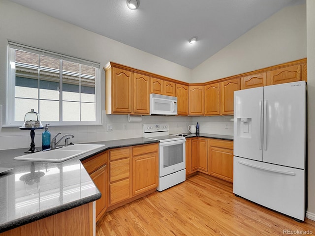 946 Champion Cir, Longmont, CO 80503 - kitchen featuring white appliances, a sink, vaulted ceiling, light wood-type flooring, and tasteful backsplash
