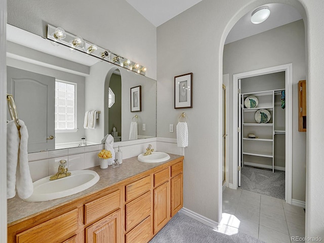 946 Champion Cir, Longmont, CO 80503 - full bath with tile patterned flooring, double vanity, a walk in closet, and baseboards