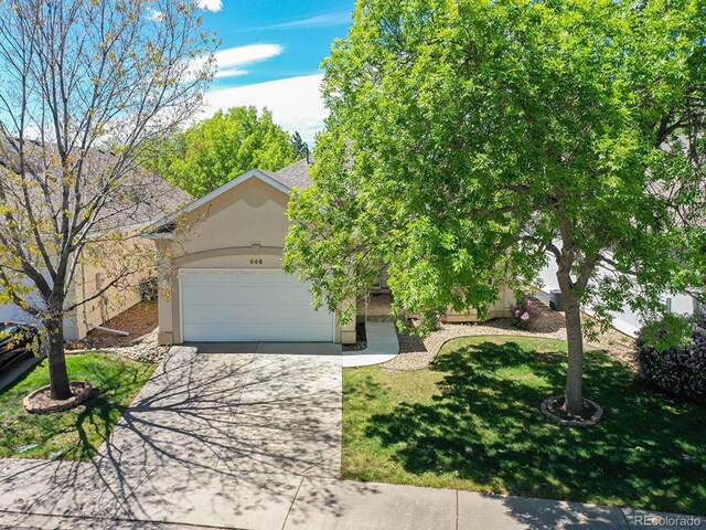 946 Champion Cir, Longmont, CO 80503 - view of front of home featuring stucco siding, an attached garage, concrete driveway, and a front yard