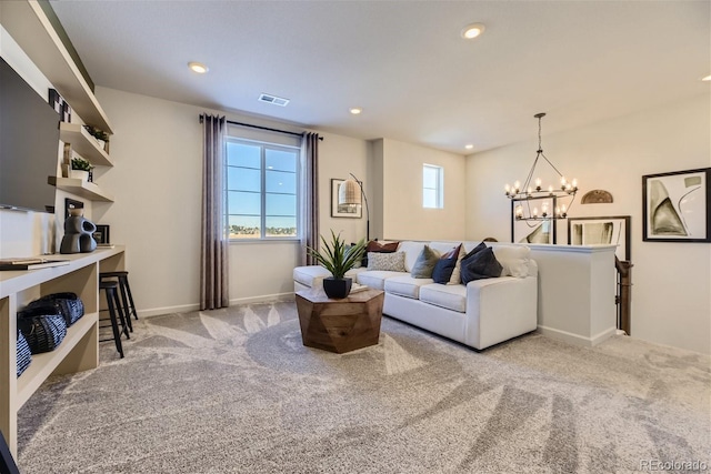 carpeted living room with an inviting chandelier