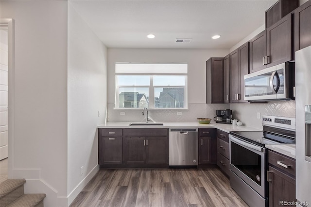 2080 Alcott Way, Broomfield, CO 80023 - kitchen featuring stainless steel appliances, a sink, light countertops, dark brown cabinetry, and wood finished floors