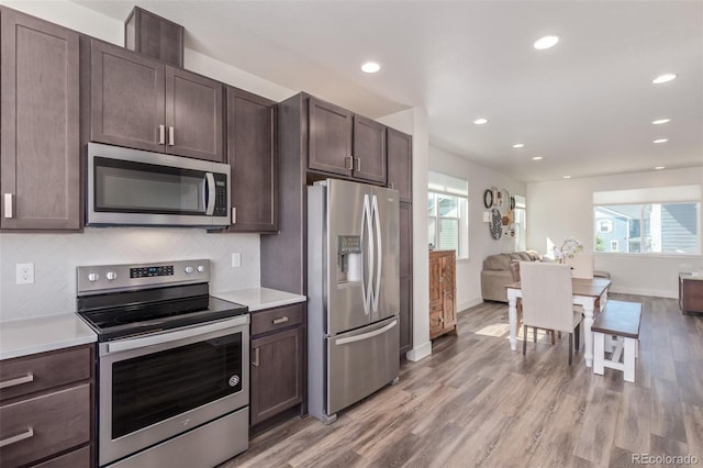 2080 Alcott Way, Broomfield, CO 80023 - kitchen featuring stainless steel appliances, dark brown cabinetry, light countertops, open floor plan, and recessed lighting