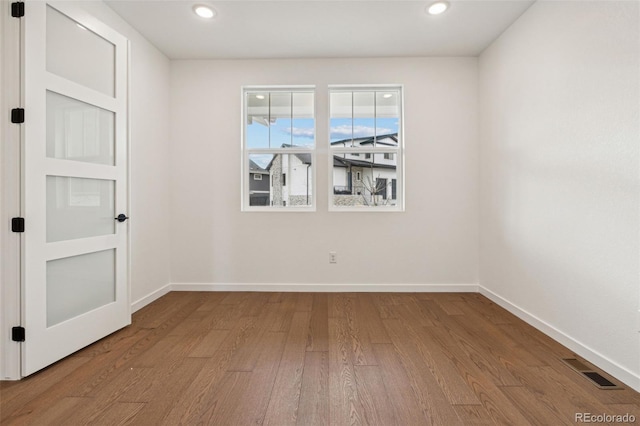 unfurnished room with hardwood / wood-style flooring