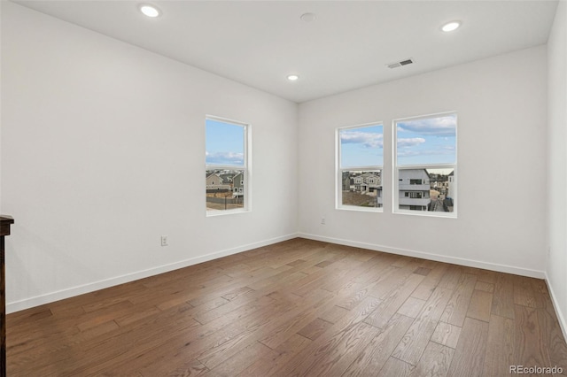 empty room featuring hardwood / wood-style floors and plenty of natural light