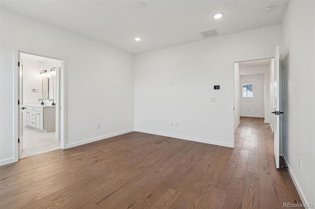 unfurnished room with light hardwood / wood-style floors and sink