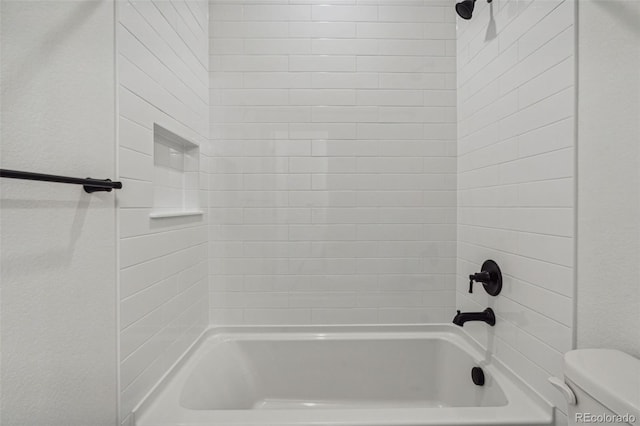 bathroom with toilet and tiled shower / bath