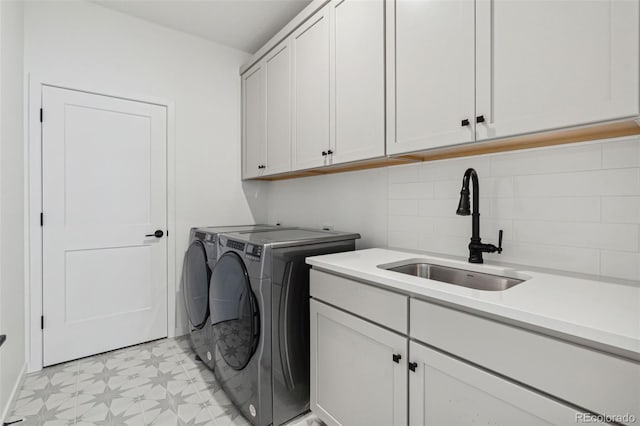 laundry room featuring cabinets, sink, and washing machine and dryer