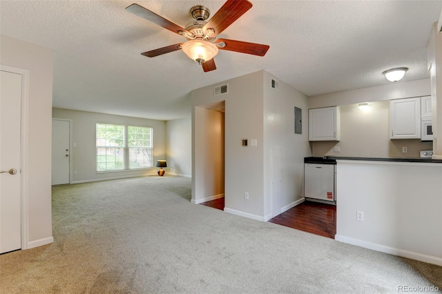 3855 S Monaco St Unit 177, Denver, CO 80237 - unfurnished living room featuring carpet flooring, a textured ceiling, a ceiling fan, and baseboards