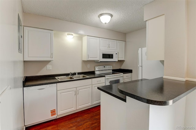 3855 S Monaco St Unit 177, Denver, CO 80237 - kitchen with white appliances, a sink, a peninsula, dark countertops, and white cabinetry