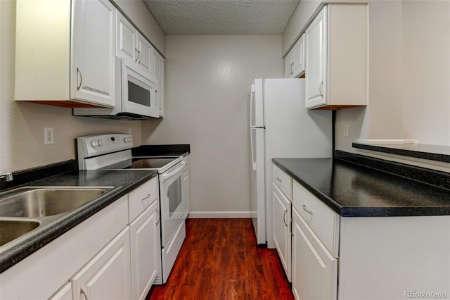 3855 S Monaco St Unit 177, Denver, CO 80237 - kitchen featuring white appliances, white cabinets, dark wood finished floors, dark countertops, and a textured ceiling