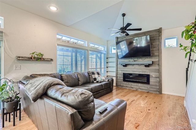 living room with ceiling fan, plenty of natural light, lofted ceiling, and light wood-type flooring