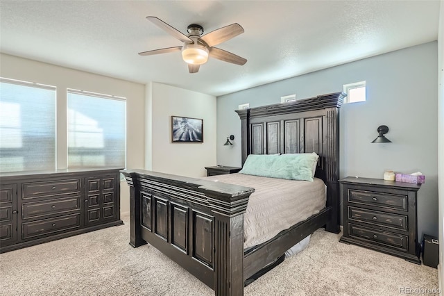 bedroom featuring multiple windows, ceiling fan, and light colored carpet