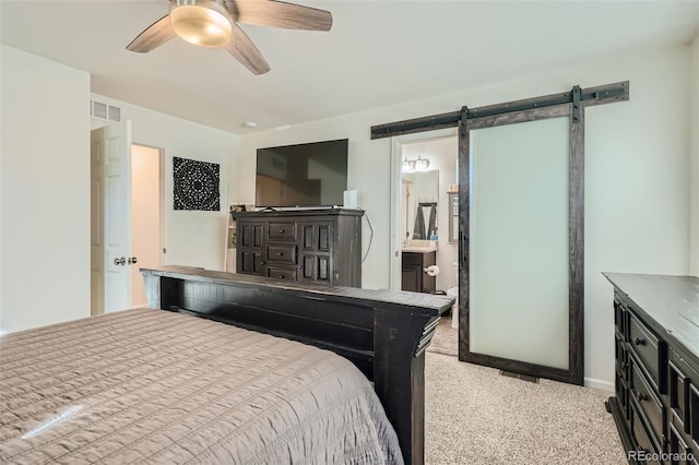 carpeted bedroom featuring ceiling fan, a barn door, and connected bathroom