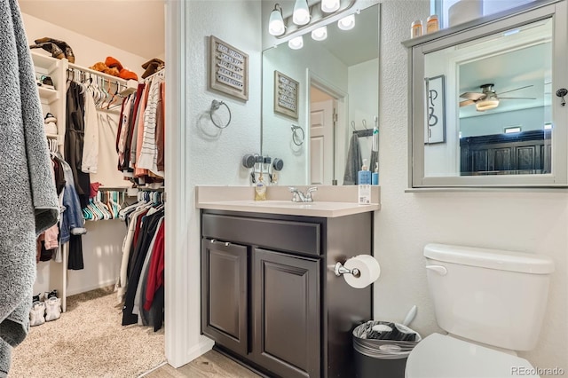 bathroom featuring vanity, toilet, and ceiling fan