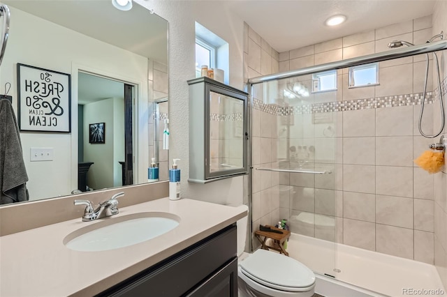 bathroom with vanity, toilet, and a shower with shower door