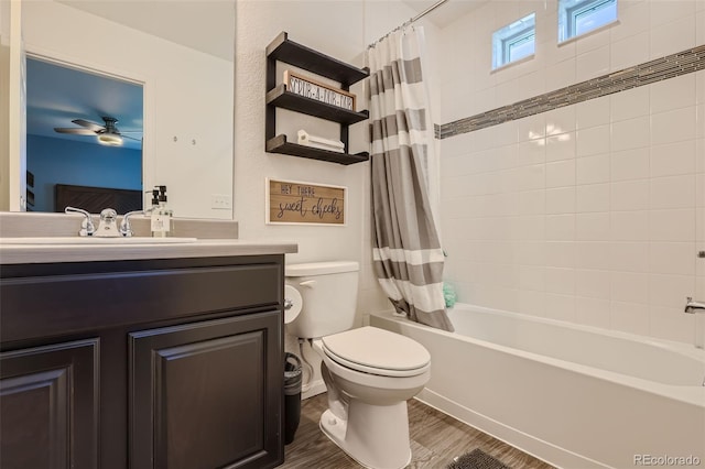 full bathroom with vanity, ceiling fan, toilet, shower / bathtub combination with curtain, and wood-type flooring