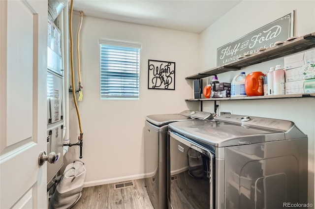 laundry area with wood-type flooring and washing machine and dryer