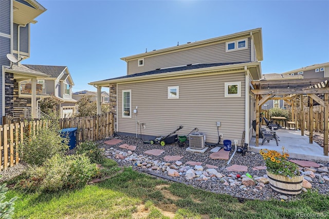 back of property with a pergola, a patio, and central AC