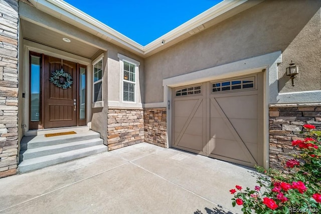 5865 Clover Ridge Cir, Castle Rock, CO 80104 - view of exterior entry featuring stone siding, stucco siding, driveway, and a garage