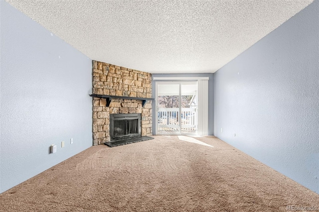 unfurnished living room with a textured wall, carpet flooring, a textured ceiling, and a stone fireplace