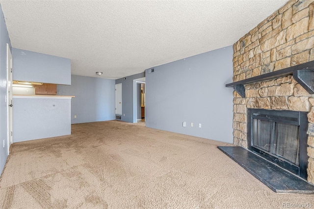 unfurnished living room with carpet, a fireplace, and a textured ceiling