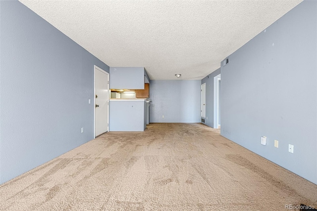 empty room with light carpet and a textured ceiling