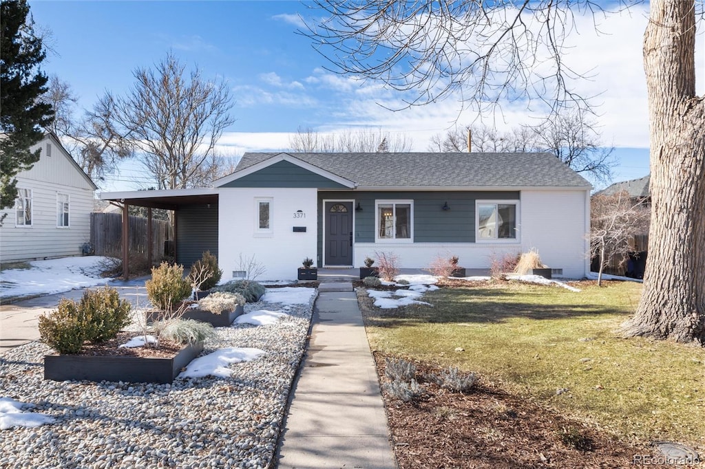 ranch-style home with a carport and a front yard