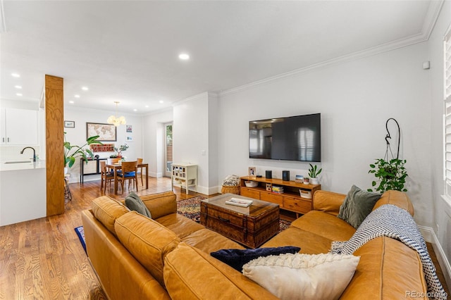 living room with light wood finished floors, baseboards, crown molding, and recessed lighting