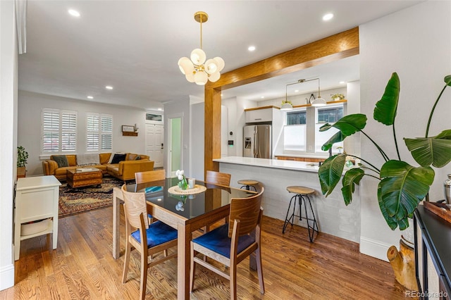 dining room with recessed lighting, a notable chandelier, plenty of natural light, and wood finished floors