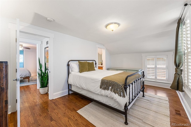 bedroom featuring visible vents, vaulted ceiling, baseboards, and wood finished floors