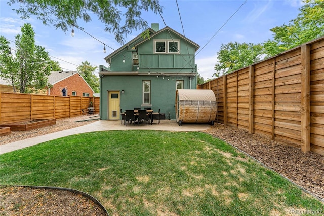 back of property featuring a fenced backyard, a yard, a vegetable garden, stucco siding, and a patio area