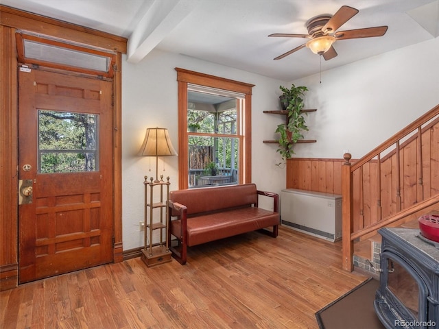 274 N Willow St, Crestone, CO 81131 - entrance foyer with a wood stove, light wood-style flooring, a ceiling fan, stairs, and beam ceiling