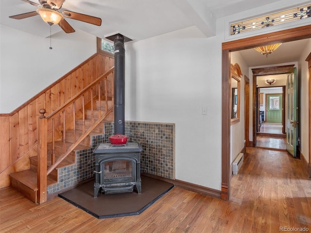 274 N Willow St, Crestone, CO 81131 - living area featuring a wood stove, wood finished floors, stairway, and ceiling fan