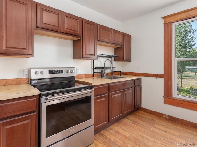 274 N Willow St, Crestone, CO 81131 - kitchen featuring electric stove, light countertops, light wood finished floors, and brown cabinets