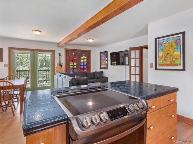 274 N Willow St, Crestone, CO 81131 - kitchen with electric stove, dark countertops, light wood-type flooring, beamed ceiling, and open floor plan