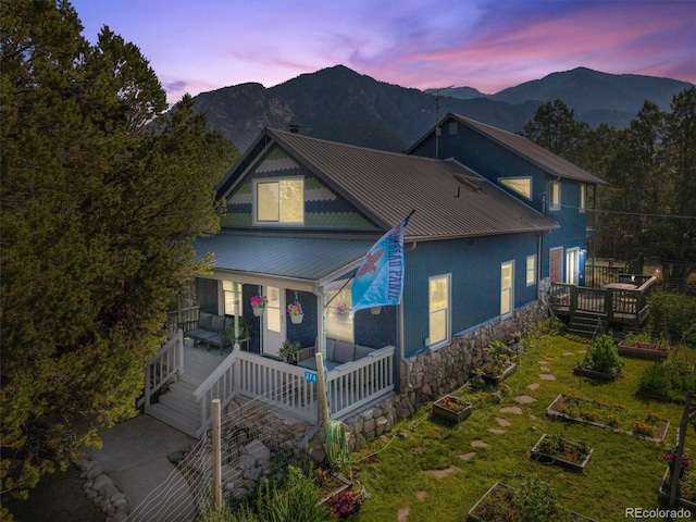 274 N Willow St, Crestone, CO 81131 - view of front of property featuring a vegetable garden, a metal roof, a mountain view, and covered porch