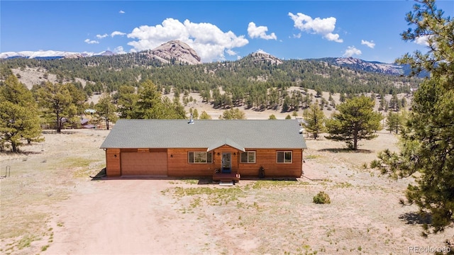 874 Hackamore Dr, Florissant, CO 80816 - view of front of home with a mountain view, driveway, a garage, and log veneer siding