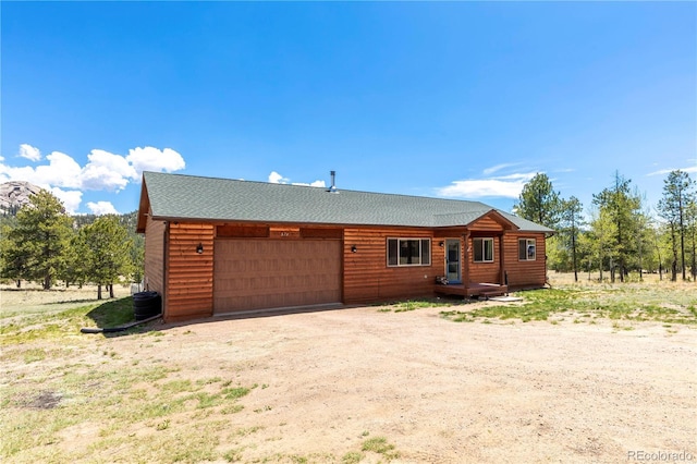 874 Hackamore Dr, Florissant, CO 80816 - log cabin with an attached garage, driveway, and a shingled roof