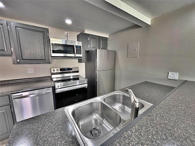 371 S Estes St Unit 10, Lakewood, CO 80226 - kitchen featuring appliances with stainless steel finishes, a sink, dark countertops, a textured wall, and recessed lighting