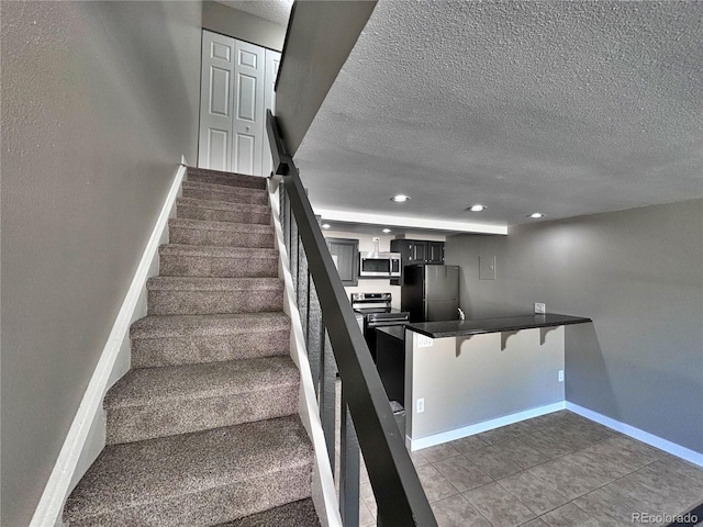 371 S Estes St Unit 10, Lakewood, CO 80226 - staircase with a textured ceiling, baseboards, recessed lighting, and tile patterned flooring