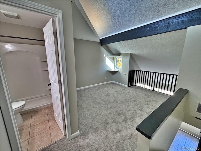 371 S Estes St Unit 10, Lakewood, CO 80226 - additional living space featuring a textured ceiling, tile patterned flooring, lofted ceiling, baseboards, and carpet