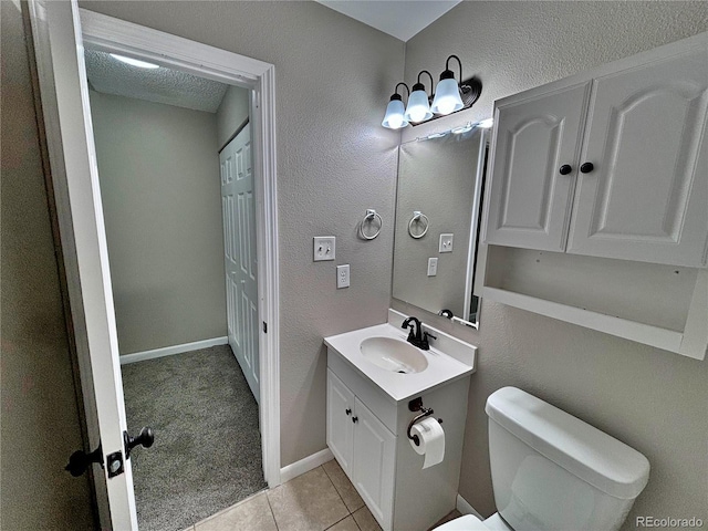 371 S Estes St Unit 10, Lakewood, CO 80226 - half bathroom with toilet, vanity, tile patterned floors, a textured wall, and baseboards
