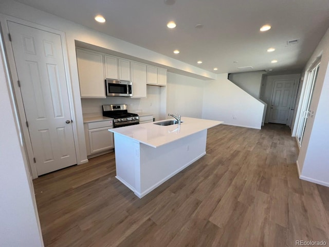 kitchen with sink, stainless steel appliances, hardwood / wood-style floors, a kitchen island with sink, and white cabinets